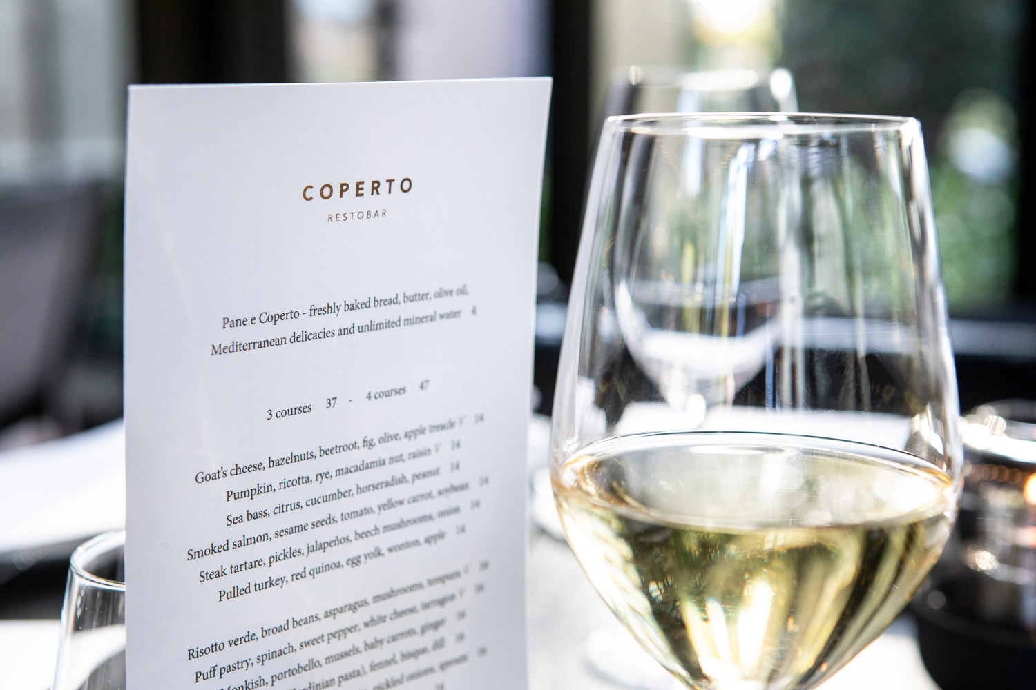 The menu card of Coperto Restobar in Zwolle with a glass of wine