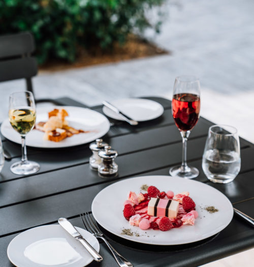 A desert with red fruit and a glass of wine on the terrace of Coperto Restobar in Zwolle