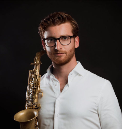 Men with saxophone in a white blouse