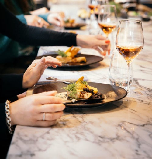 People eating and drinking at a marble bar