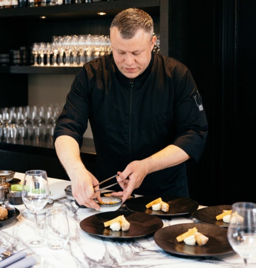 Chef preparing food at a marble bar