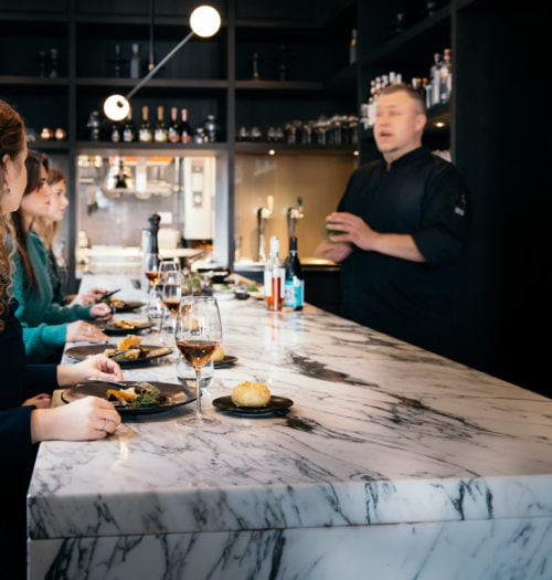 People eating and drinking at a marble table